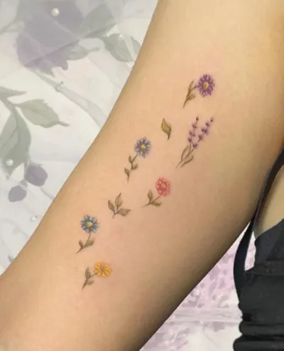 Colorful wildflower fine line tattoo by Natasha Rachel